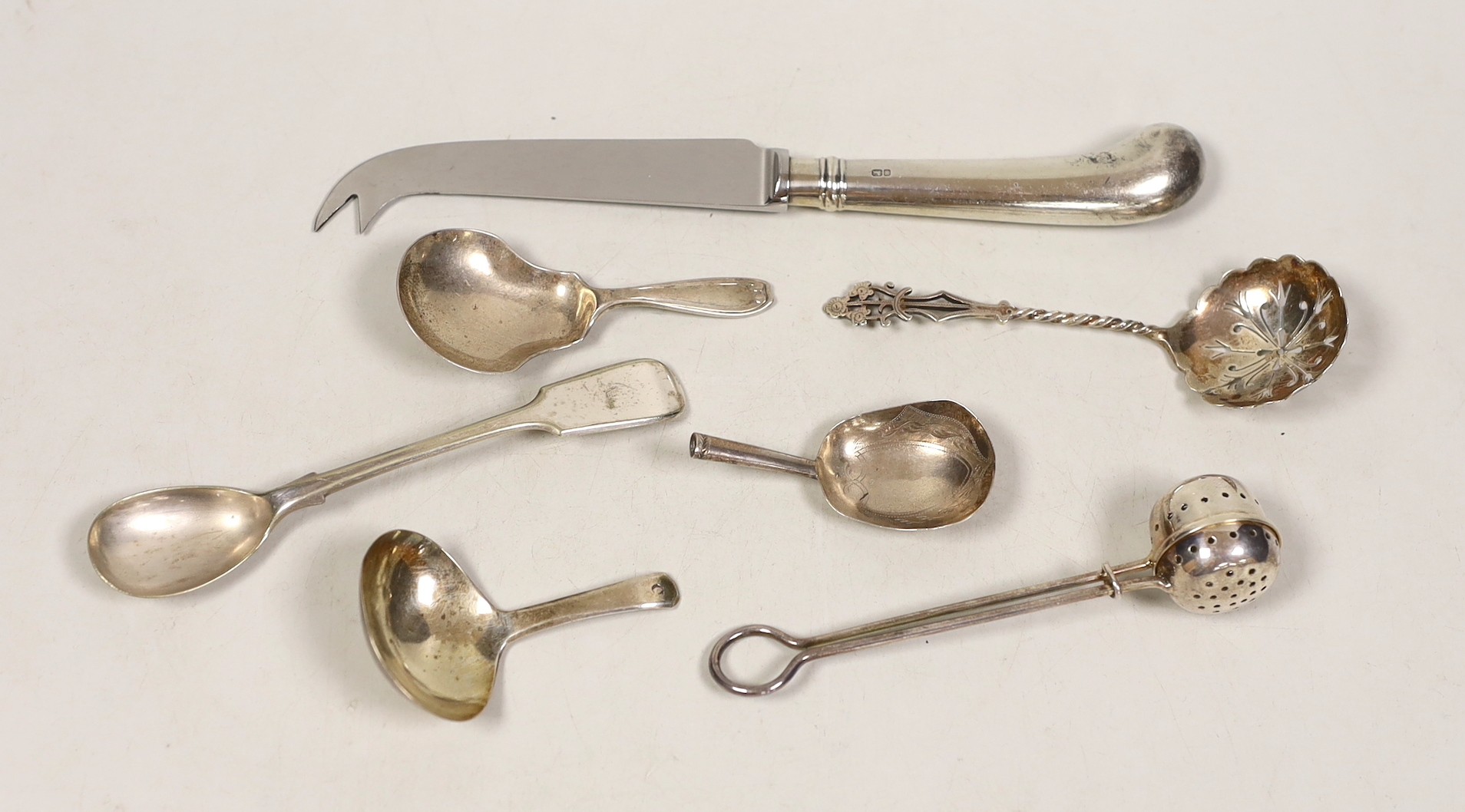 Three silver caddy spoons, including two 19th century, a silver infuser, a sifter spoon, a cheese knife and a plated condiment spoon.